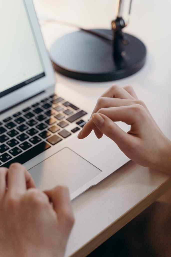 Crafting Captivating Headlines: Your awesome post title goes here Close-up of hands using a laptops touchpad in an office environment, highlighting focus and technology.