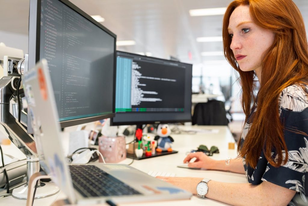 The Art of Drawing Readers In: Your attractive post title goes here A focused female software engineer coding on dual monitors in a modern office.
